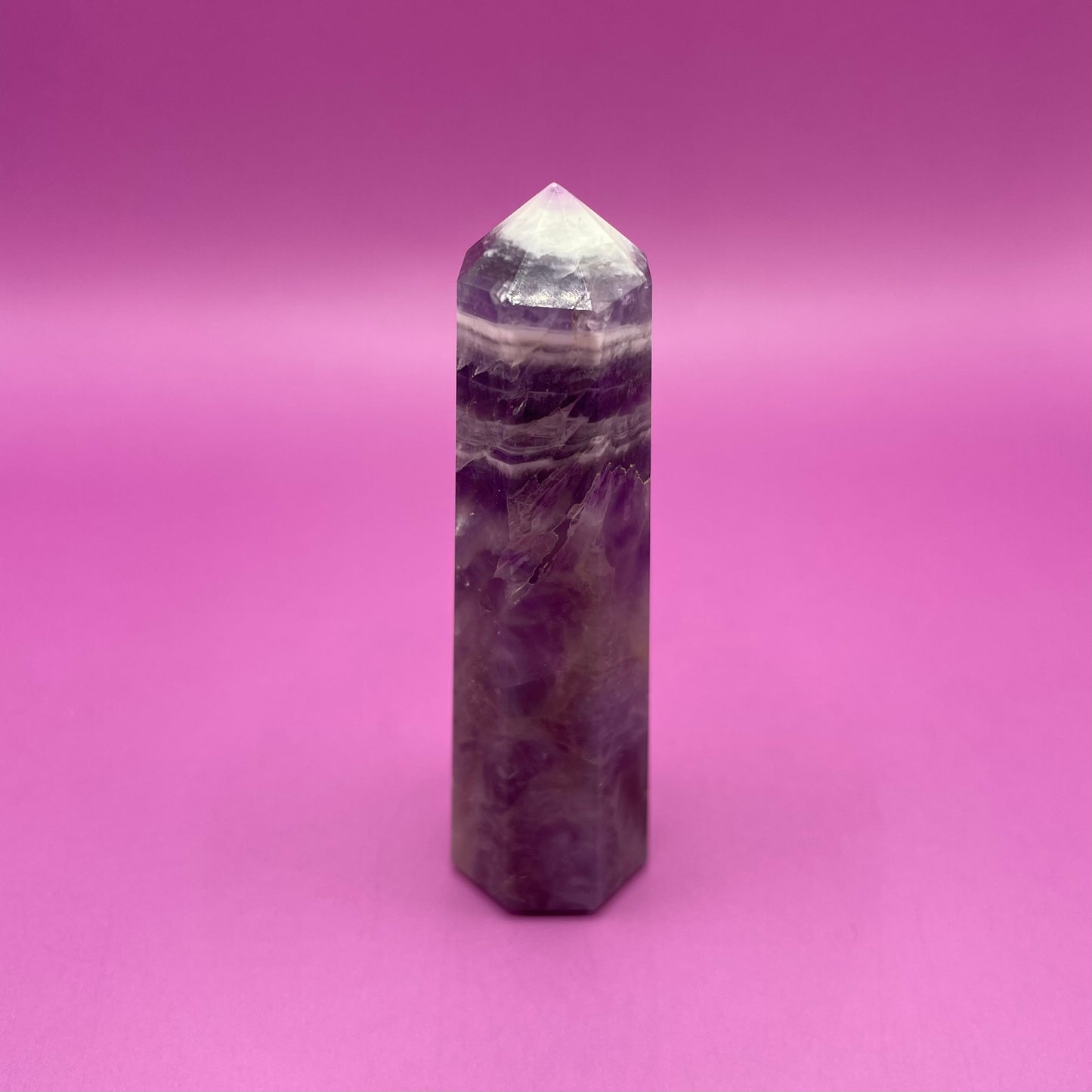 Chevron Amethyst crystal tower on a pink background