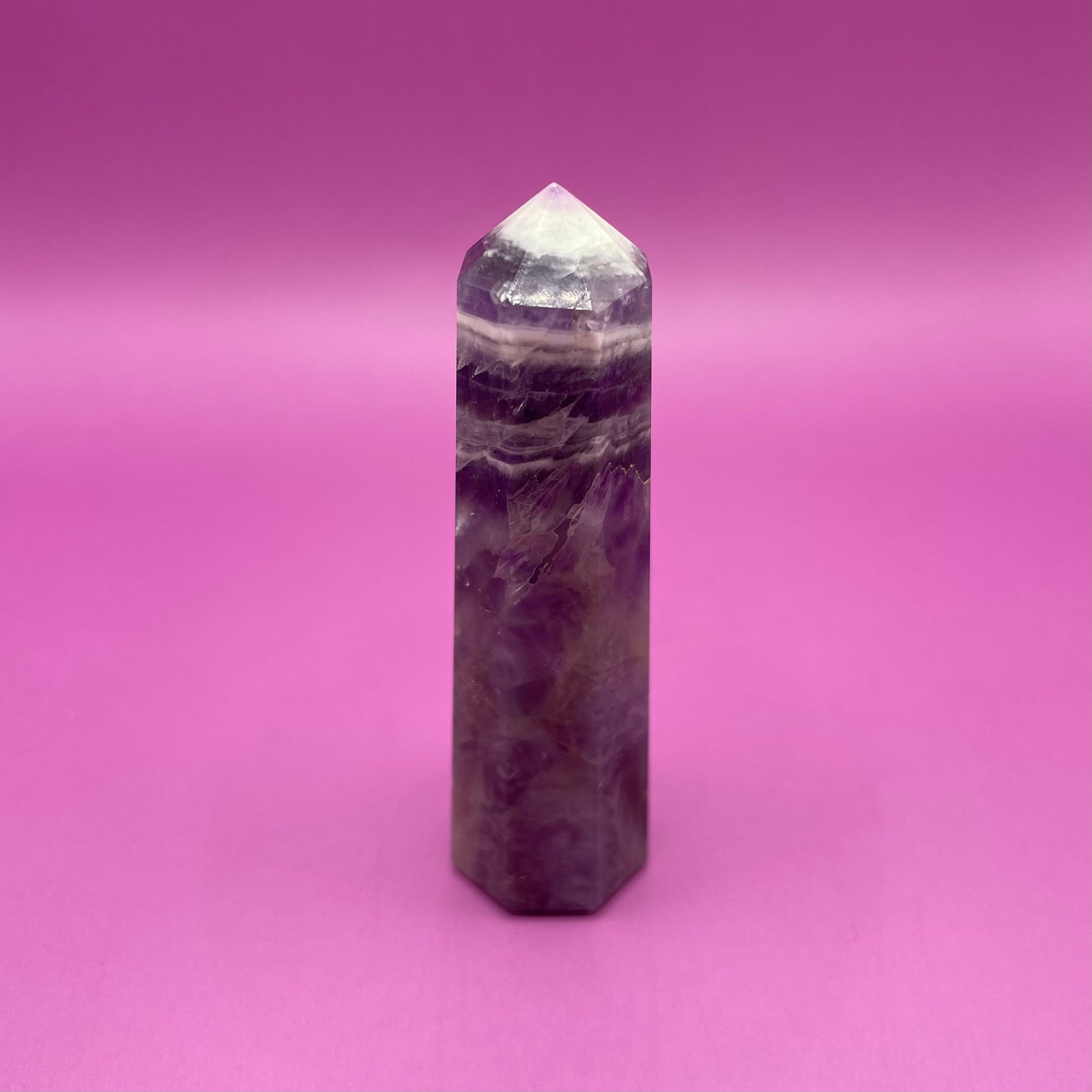 Chevron Amethyst crystal tower on a pink background