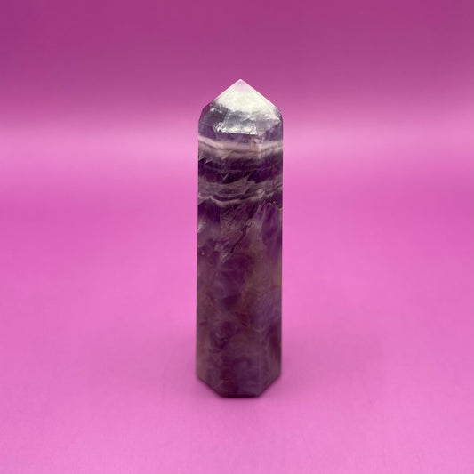 Chevron Amethyst crystal tower on a pink background